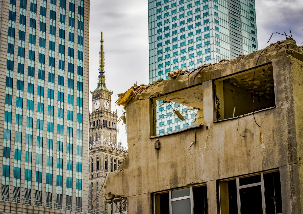 Palace of Culture and Science framed between glass towers and a ruined concrete building